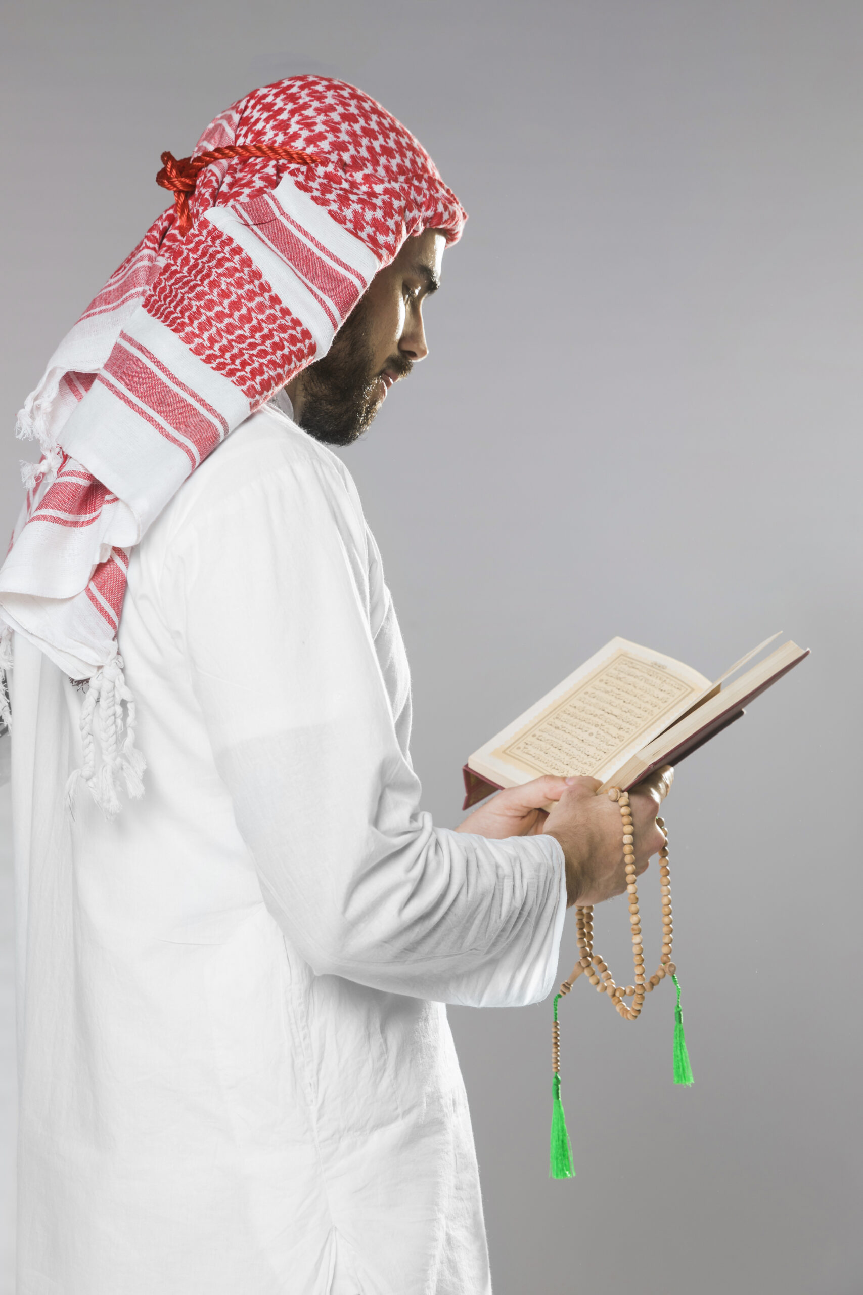 muslim man reading from quran holding praying beads scaled